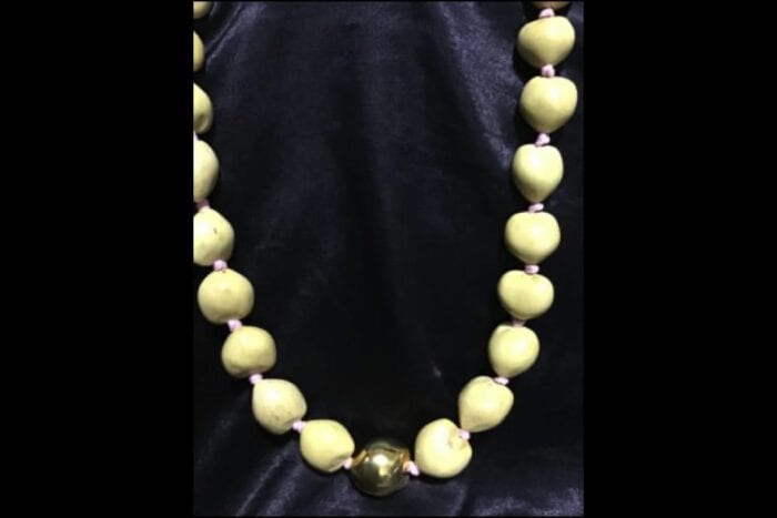 37 inch Natural Kukui Nut Lei featuring a 24K Gold Plated center Kukui Nut on a pink ribbon