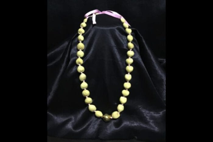 37 inch Natural Kukui Nut Lei featuring a 24K Gold Plated center Kukui Nut on a pink ribbon